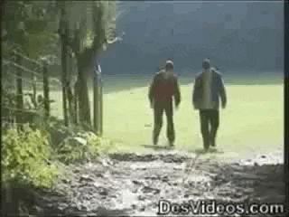 a gif of two men walking, one falls into a hole
