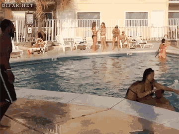 Man jumps into a pool and another man tries to imitate him but fails