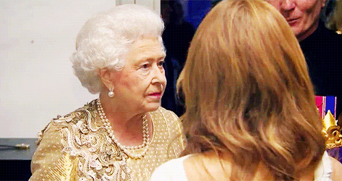 The Queen laughs and looks a little scared as she chats with guests.