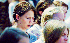 gif of Katniss Everdeen, played by Jennifer Lawrence, looking up from the ground somberly as she is chosen as tribute