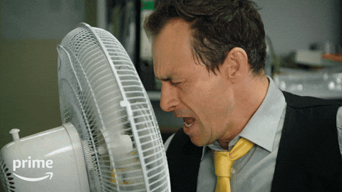 Man in a shirt and tie singing into a desk fan