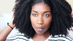 an gif of Whitney White with 4a hair playing with her curls