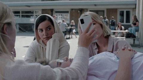 mujer viendo una fotografía tomada con una cámara de 12 MP mientras asiente en señal de estar satisfecha con el resultado.- Blog Hola Telcel 