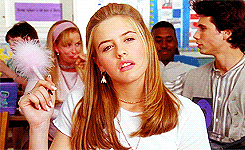 Alicia Silverstone thinking deeply while holding a pen
