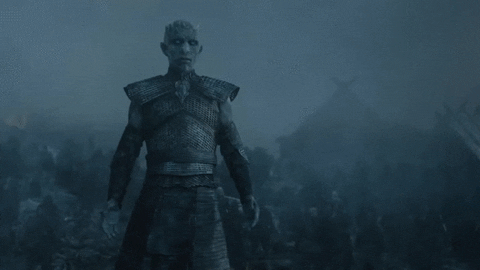 The Night King raising his arms up while looking at Jon Snow.
