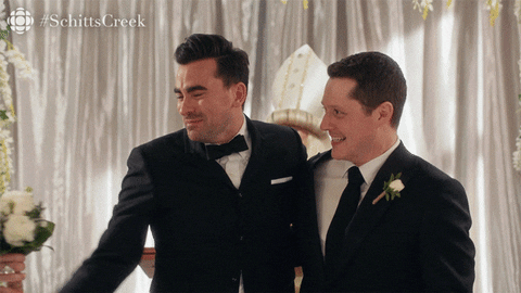 GIF of David and Patrick from Schitt's Creek walking down the aisle after getting married