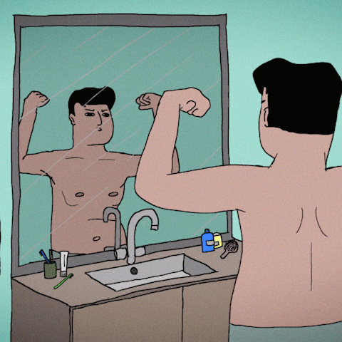 Moški povprečnega izgleda se napenja pred ogledalom.