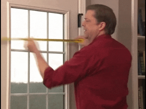 Señor confundido midiendo el marco de una puerta con una cinta de medir 