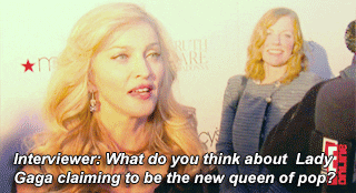 Madonna being interviewed by reporters on a red carpet. 