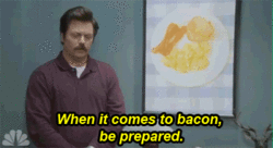Ron Swanson animate gif "when it comes to bacon, be prepared." As he turns a framed image on his wall to show bacon hidden behind it.