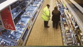 Shopper moving through a supermarket aisle with a cart