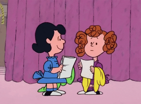 a GIF of Frieda from Charlie Brown playing with her curls