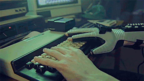 Imagen de una persona haciendo como que escribe en un teclado mientras en la pantalla aparecen letras sin sentido