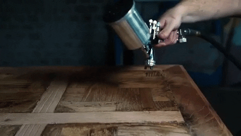 applying clear sealer to a small wooden table