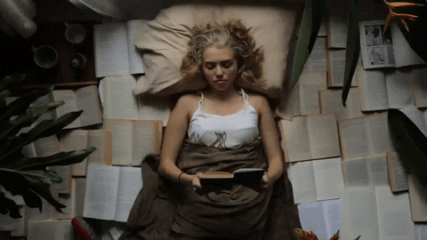 Girl lying in bed surrounded by open books which are turning pages in that speeded-up slow-mo type thing. I realise that was an awkward description. I can't think of a better one.