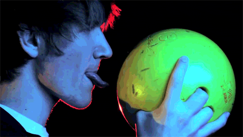 Man licking a bowling bowl provocatively