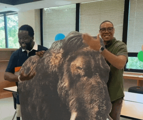 A GIF showing Principal McCray and Chancellor Ferebee with a large mammoth cut-out.