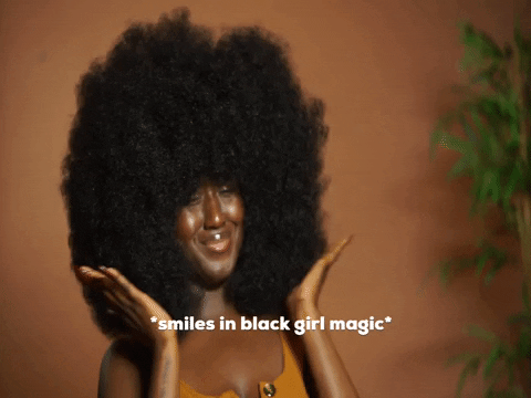a GIF of a black woman patting her large afro with the caption *smiles in black girl magic*