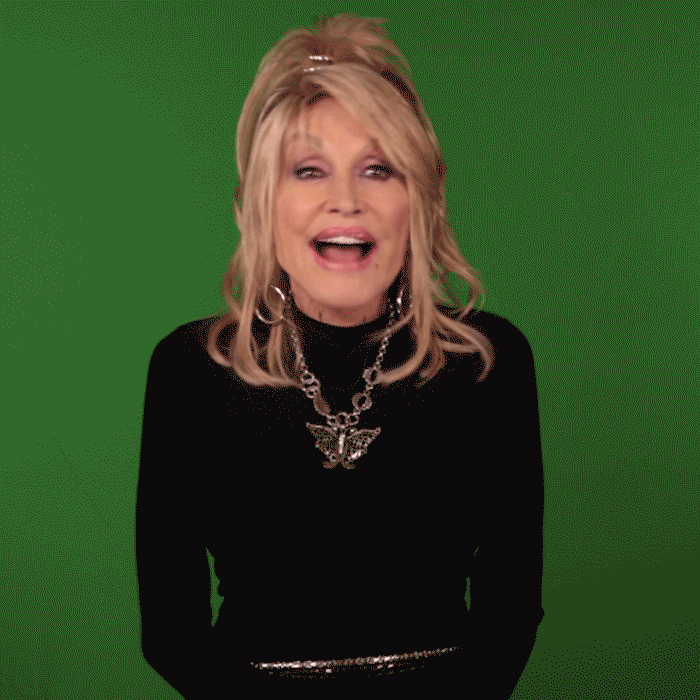 A GIF of Dolly Parton acting surprised in front of a green background.