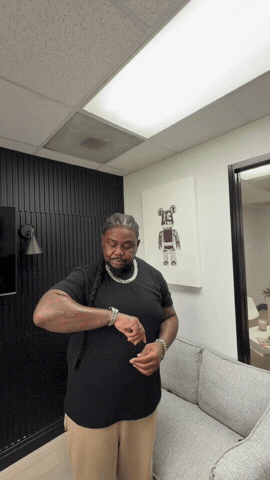 Man in a shirt raising his arm to check the time on his wristwatch