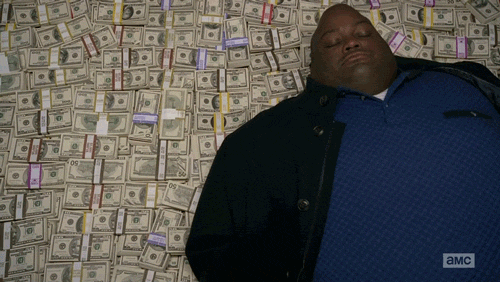 Huell laying on a pile of cash. 