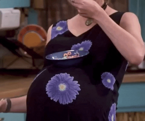 Zwangere vrouw zet bordje op haar buik