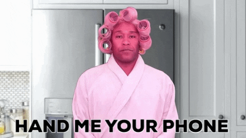 Social media detox: Man in rollers and pink robe asking for phone.
