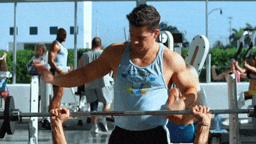 A gif of two people lifting weights and one of them being super pumped up.