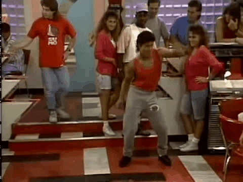 A gif of Slater dancing on Saved by the Bell, with a group of people standing around in a room during a Quinceanera.