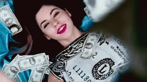 Girl laying down on bills with money falling over her
