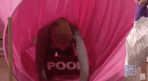 man going through a colon tunnel with poop sign around his neck