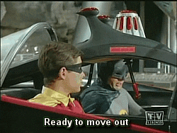Fotograma de la serie clásica de Batman en la que él y Robin salen de la Batcueva con su Batmóvil