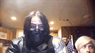 spoof/cosplay Bucky Barnes as Winter Soldier with Steve appearing slowly from under the desk holding US flags gif