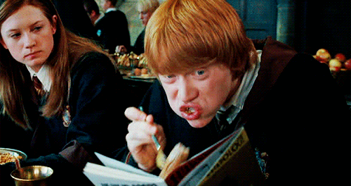 Cena de Harry Potter: menino ruivo lendo em inglês enquanto come