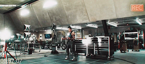 GIF of Iron Man/Tony Stark (Robert Downey, Jr.) being sent flying through the air in his lab while testing flight boots in Iron Man