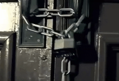 A GIF showing a door chained and locked with a padlock