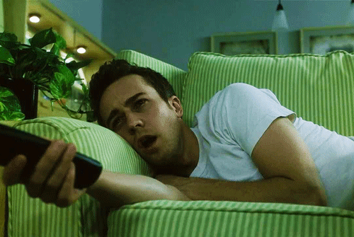 Fight club movie scene: Lazy Edward Norton lying on couch watching TV