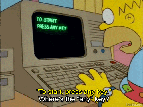 Homer Simpson, character on The Simpsons, is hovering his hands over a computer. The computer screen shows the message "to start press any key" and Homer asks: "Where's the 'any' key?"