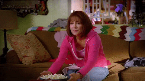 mulher comendo pipoca enquanto assiste TV