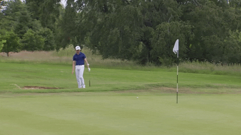 A gif of a professional woman golfer getting frustrated and throwing her h and up after missing an easy putt from the yips