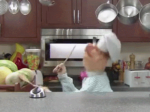 puppet doll chef dancing in a kitchen