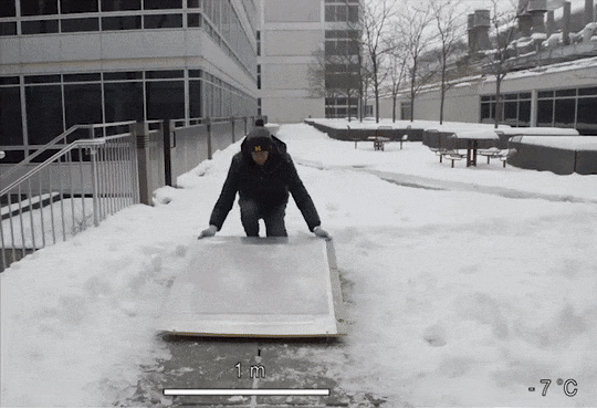 Ice sliding off a sheet of metal coated with OPERA Lab's icephobic treatment.