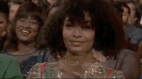 a GIF of Yara Shahidi smiling and clapping, showing her Type 3 curly hair (3c)