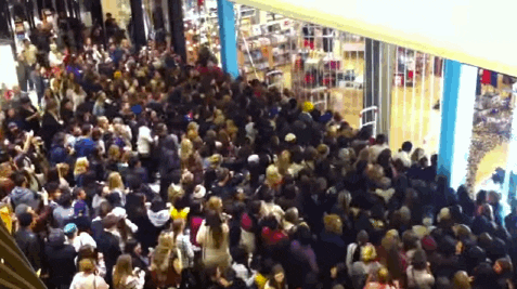 A gif of a packed crowd rushing into a store that just opened its doors.
