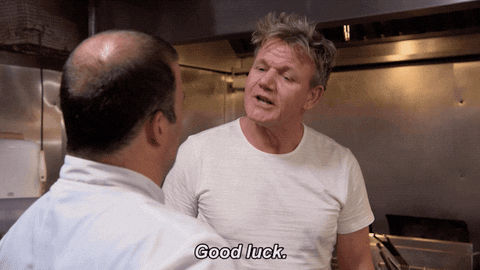A GIF of Gordon Ramsay shaking the hand of a man in a chefs outfit the giving him a hug and saying 