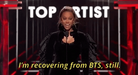 [Image description: Tyra Banks is pictured gesturing emphatically and saying, “I'm recovering from BTS, still.”] Attribution: Giphy.com