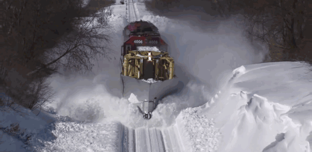 White spray of snow plowed by a train