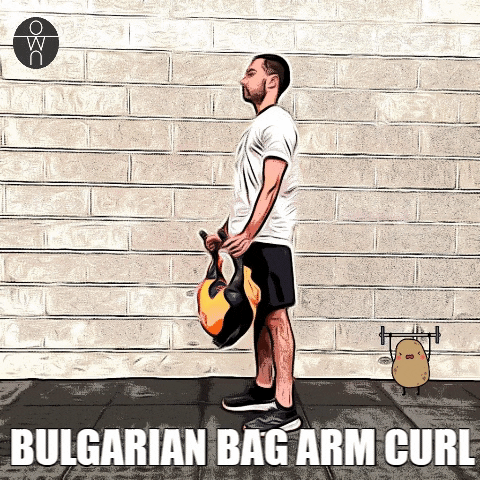 Un coach personnel Ownsport soulève le bulgarian bag pour faire le arm curl.