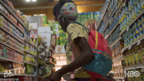 black woman dancing in health food store grocery aisle