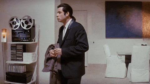 Pulp Fiction: John Travolta, holding a jacket, turns around in an empty apartment looking confused.